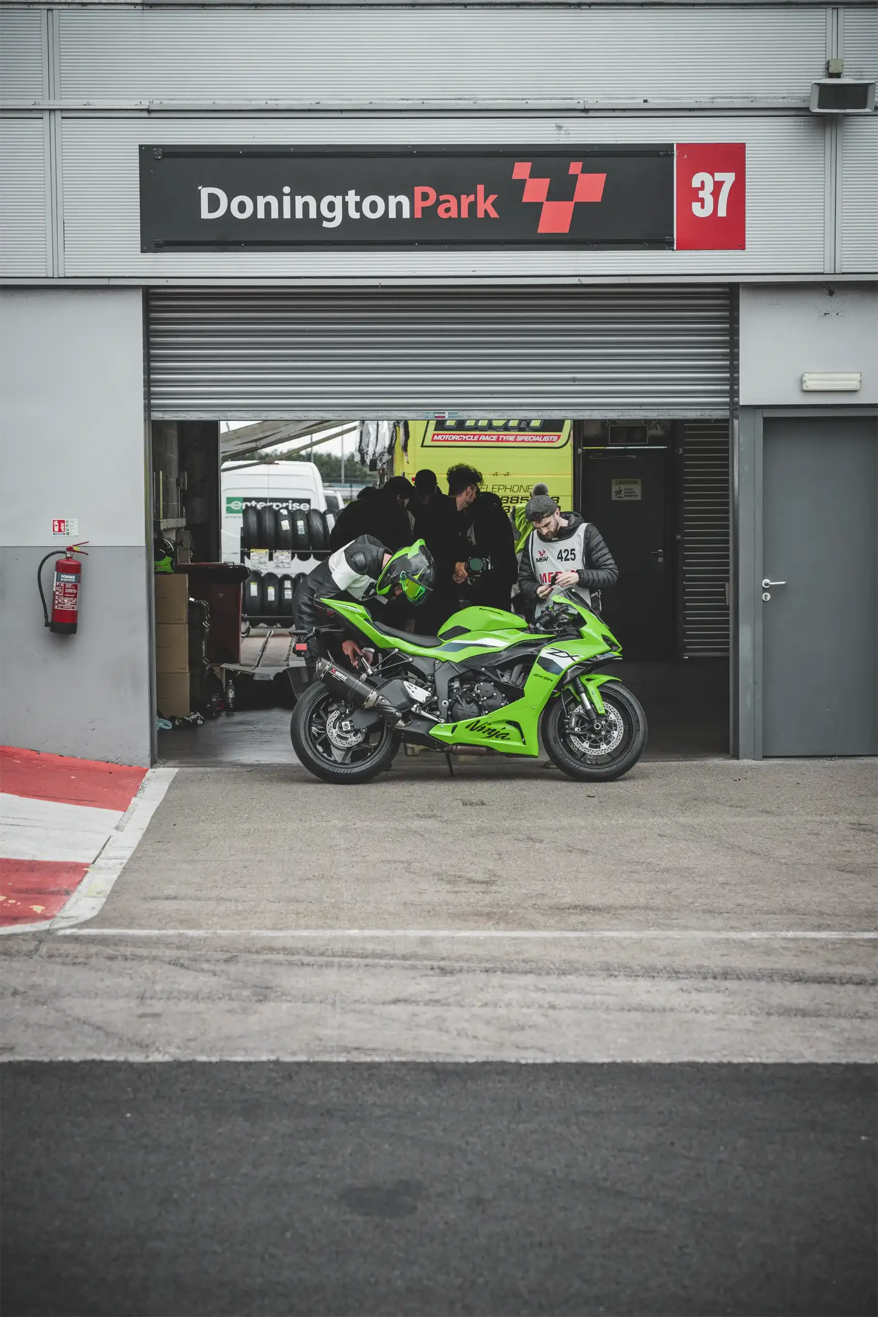 Un piloto revisando una moto en el paddock antes de una sesión en pista