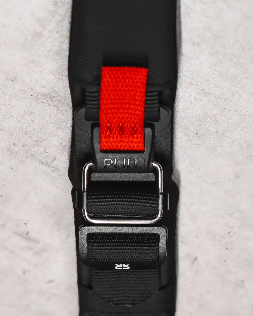 A rider pulling the red release tab on a Fidlock buckle